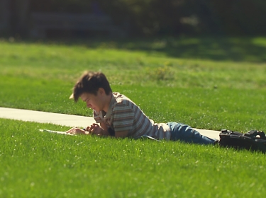 A student reads on a university lawn