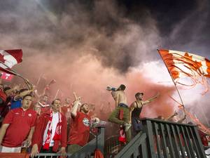 9 September 2014: Canadian fans cheer amidst smoke from a smoke bomb following Canada's tying goal against Jamaica during first half of an international friendly soccer game in Toronto
