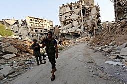 Rebel fighters walk in Aleppo, Syria