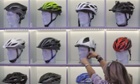 A woman fastens a helmet from the German manufacterer Uvex onto a mannequin head at the Eurobike trade show in Friedrichshafen, Germany, 31 August 2011.