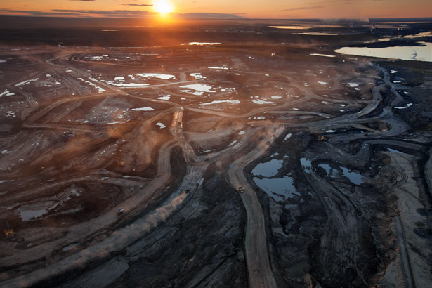 Dust hangs in the sunset sky above the Suncor Millennium mine, an open-pit north of Fort McMurray, Alberta.