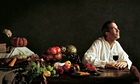 Yotam Ottolenghi at a table laden with a feast of fruit and veg