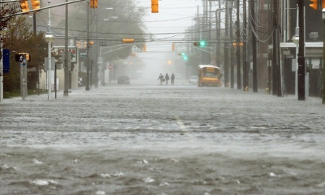 People walk down a flooded street in Atlantic City, New Jersey, as Hurricane Sandy moves up the coast.