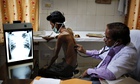 An Indian doctor examines a tuberculosis patient
