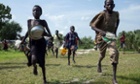 Children race into the drop zone to gather any food or seeds that were spilled during the air drop in Leer, South Sudan, on July 5, 2014.