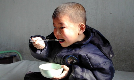 A boy eats enriched food supplied by the United Nations World Food Programme (WFP) at a hospital in south Pyongan province in 2004.