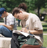 photo of student reading on bench