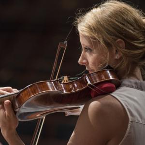 Student with violin in symphony rehearsal