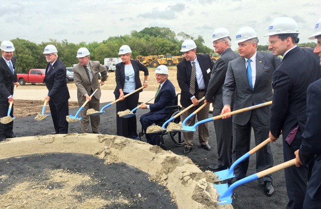 Image of Photo of an event where people are shoveling with hard hats on