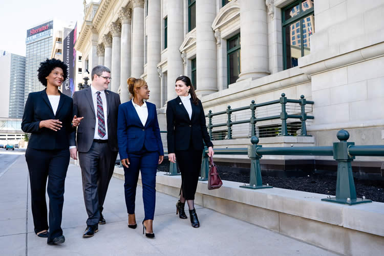 College of Law students walk along the sidewalk.