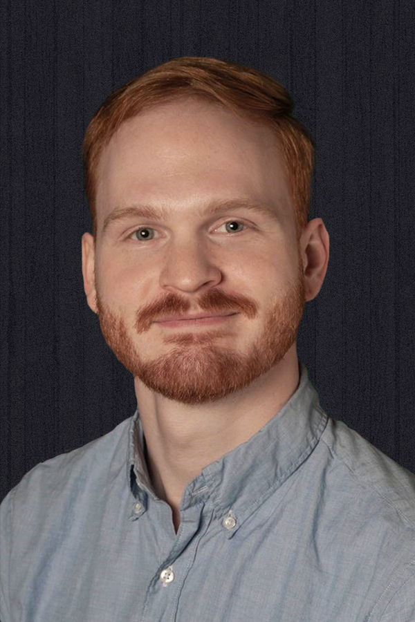 headshot of a smiling man with red hair and beard