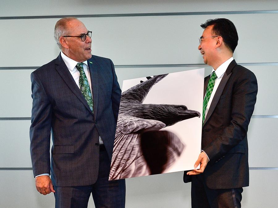 <p>President Neil Smatresk presents NetDragon founder Dejian Liu with an eagle painting at the NetDragon Digital Research Centre launch announcement May 15. The centre will offer students and faculty sponsored research and technology development opportunitie</p>
