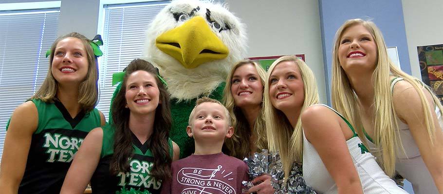 Cheerleaders, Dancers and Scrappy with a young Mean Green fan