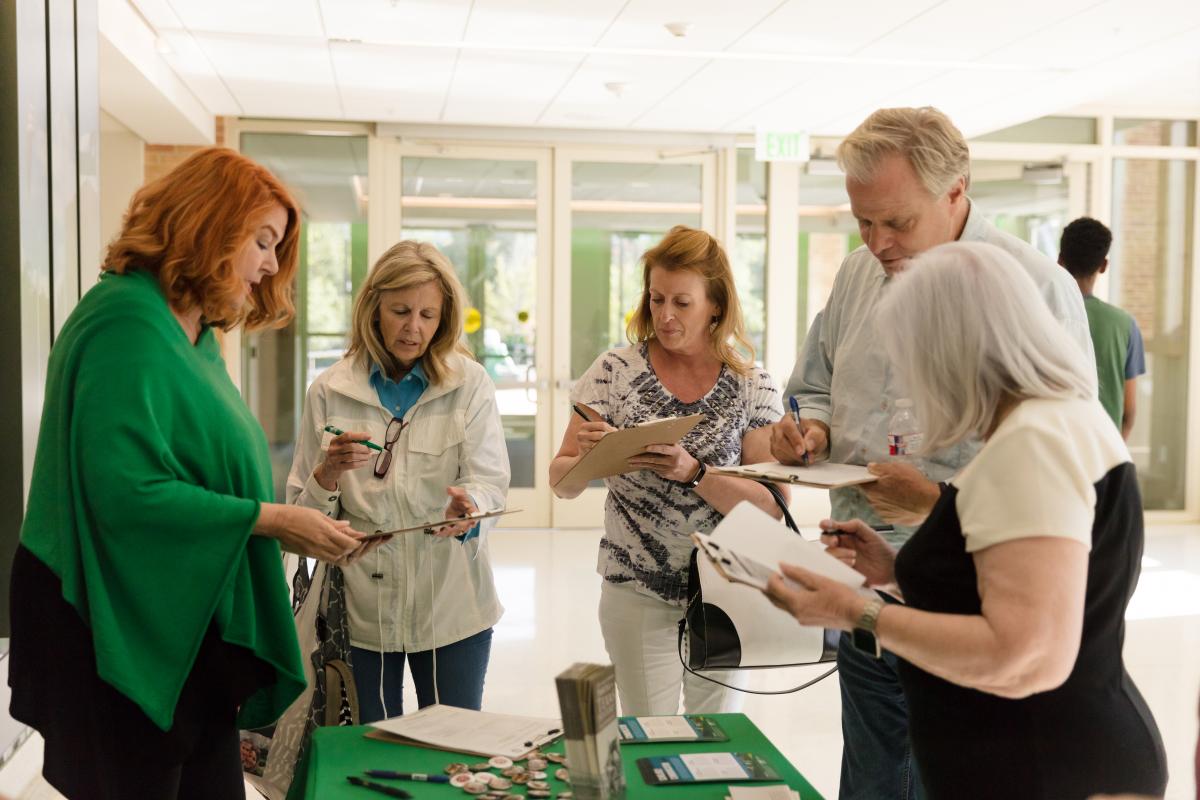 five people standing around a table