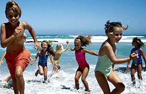 A group of kids playing at the beach.