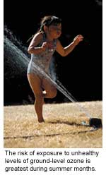 A young girl playing in a sprinkler.