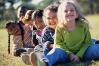 Photograph of smiling children sitting outside