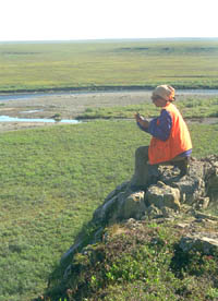 A petroleum geologist taking a compass reading in the field