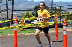Brian Harrington charges over the finish line finishing the race first with a time of 20:16, during the 12th annuel 5K Grueler Sept. 17.  