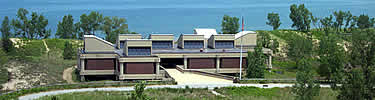 large building with trail going in the front and the beach and lake michigan visable in the back