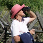 Woman using binoculars to look for birds.