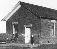 (NPS photo) Children pose in front of Freeman School at Homestead NM