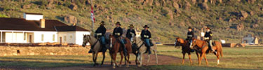 Column of cavalry re-enactors passing in review.