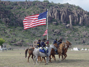 10th Cavalry reenactors performing intricate mounted drill on parade ground at Fort Davis.