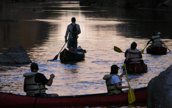 An outfitter guides a group of canoes upstream into Santa Elena Canyon