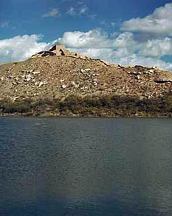 (NPS Photo) Distant view of a pueblo village on a desert hilltop at Tuzigoot National Monument