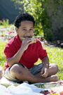 Image of a boy eating a sandwich in the park