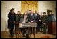 President George W. Bush is joined by legislators, cabinet members and law enforcement officials, Tuesday, Oct. 18, 2005 in the East Room of the White House, as he signs the Homeland Security Appropriations Act for fiscal year 2006.  White House photo by Paul Morse