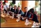 President George W. Bush speaks with National Security Advisor Condoleezza Rice at the start of the group meeting with ASEAN leaders 10th APEC leaders meeting in Los Cabos, Mexico, Saturday, Oct. 26, 2002. Also pictured seated from left are His Majesty Sultan Haji Hassanal Bolkiah Mu'Izzaddin Waddaulah and Pehin Dato Lim Jock Seng both of Brunei and Chief of Staff Andy Card.  