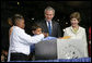 President George W. Bush and Mrs. Laura Bush have a little help onstage Sunday, May 13, 2007, placing items in a time capsule during the 400th anniversary celebration of Jamestown. White House photo by Eric Draper