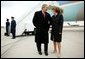 President George W. Bush talks with USA Freedom Corps greeter Gloria Grandone after arriving in Appleton, Wis., Tuesday, March 30, 2004. President Bush traveled to Wisconsin to discuss his plan to strengthen the economy and help small businesses create jobs. White House photo by Eric Draper