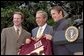 President George W. Bush accepts a team jersey from the NCAA Championship hockey team from the University of Minnesota on the South Lawn Tuesday, May 21. Also attending were University of Connecticut's women's basketball team, University of Maryland's men's basketball team, and University of Minnesota's women's hockey team. White House photo by Tina Hager.