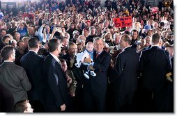 President George W. Bush poses with a baby while greeting the crowd during the Indiana Welcome at the South Bend Regional Airport in South Bend, Ind., Oct. 31. White House photo by Tina Hager.