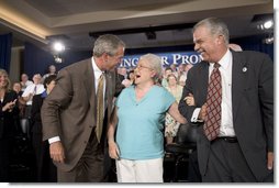 President George W. Bush and Margaret Cantrell break out in laughter on stage Monday, Aug. 29, 2005, at the Pueblo El Mirage RV Resort and Country Club in El Mirage, Arizona. The 82-year-old retired Scottsdale grandmother was on hand to lend support to the President's Conversation on Medicare. White House photo by Paul Morse