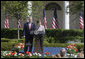 Mrs. Laura Bush and President George W. Bush address guests in the Rose Garden during an event honoring the recipients of the Preserve America Presidential Awards May 1, 2006. White House photo by Kimberlee Hewitt