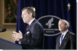 Mike Leavitt, newly sworn-in Secretary of Health and Human Services, addresses the audience after receiving the oath of office during ceremonies Friday, Feb.11, 2005, in the Great Hall at the U.S. Department of Health and Human Services. President George W. Bush looks on after introducing Secretary Leavitt.  White House photo by Paul Morse