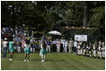 President George W. Bush stands for the singing of the national anthem with representatives of the All-American Girls Professional Baseball League Players Association during the opening ceremony for the last game of the 2003 White House South Lawn Tee Ball season Sunday, Sept. 7, 2003. The AAGPBL gave more than 600 woman the opportunity to play professional baseball from 1943 to 1954.