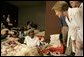 Laura Bush leans down to comfort a woman and her young child inside the Cajundome at the University of Louisiana in Lafayette, Friday, Sept. 2, 2005, during her visit to the center, one of many created to accommodate victims of Hurricane Katrina. White House photo by Krisanne Johnson