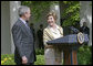 Laura Bush looks over to President Bush during a Rose Garden announcement honoring the 2005 Preserve America Presidential Awards Winners Monday, May 2, 2005. "These awards recognize collaborative efforts to protect and enhance our nation's cultural and historical heritage," said Mrs. Bush in her remarks.White House photo by Eric Draper