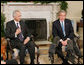 President George W. Bush is joined by Samir Sumaidaie, Iraq Ambassador to the United Nations, in the Oval Office Friday, Dec. 16, 2005. The Ambassador holds up his finger, dyed purple to signify his vote yesterday in his country's parliamentary elections.  White House photo by Paul Morse