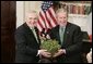 President George W. Bush accepts a bowl of shamrocks from Irish Prime Minister Bertie Ahern during a ceremony celebrating St. Patrick's Day in the Roosevelt Room Thursday, March 17, 2005.  White House photo by Paul Morse