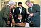 Meeting with this year's March of Dimes ambassador in the Oval Office, President Bush shows off his boots that carry the presidential seal and a red, white, & blue outline of the lone star state. White House photo by Moreen Ishikawa.