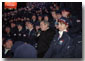 Taking a phone call from an athlete's family, President George W. Bush sits with America's Olympic athletes during the opening ceremonies for the 2002 Winter Olympic Games in Salt Lake City, Utah, Feb. 8. White House photo by Paul Morse.