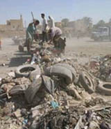 Partcipants in a USAID financed cleanup of the El Rashid neighborhood of Baghdad deliver garbage to collection spots where it is trucked to landfills. 