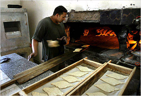 An Iraqi baker cooks traditional bread in Baghdad April 22, 2003. More small businesses reopen every day as life slowly returns to normal in Baghdad. © AP/Wide World Photo/Jean-Marc Bouju