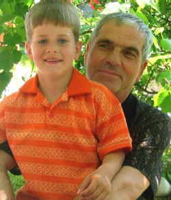 Five-year-old Amel takes a break from bike riding to sit on the lap of his foster father Esef Jusic.